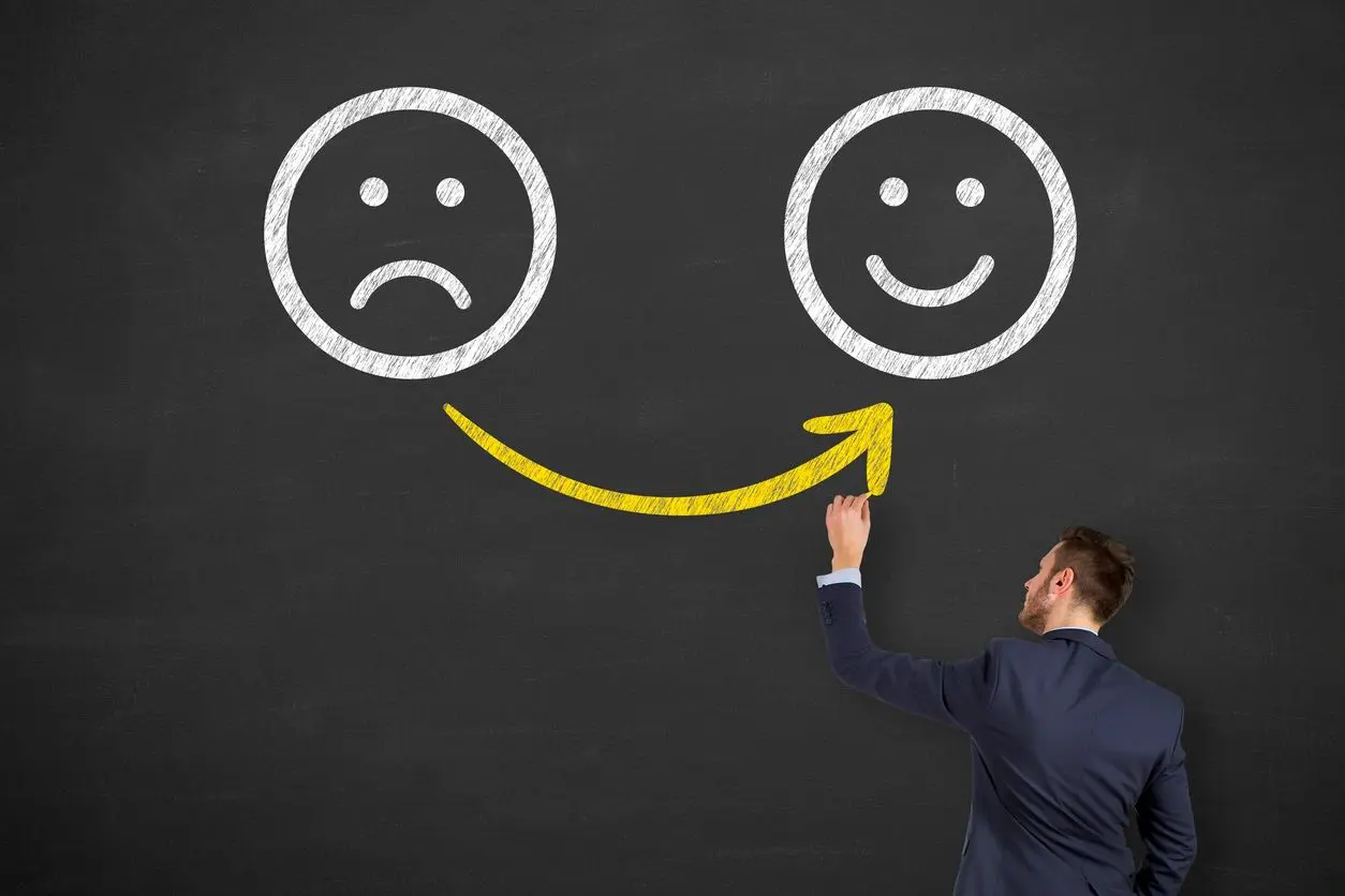 A man drawing two smiley faces on the wall.